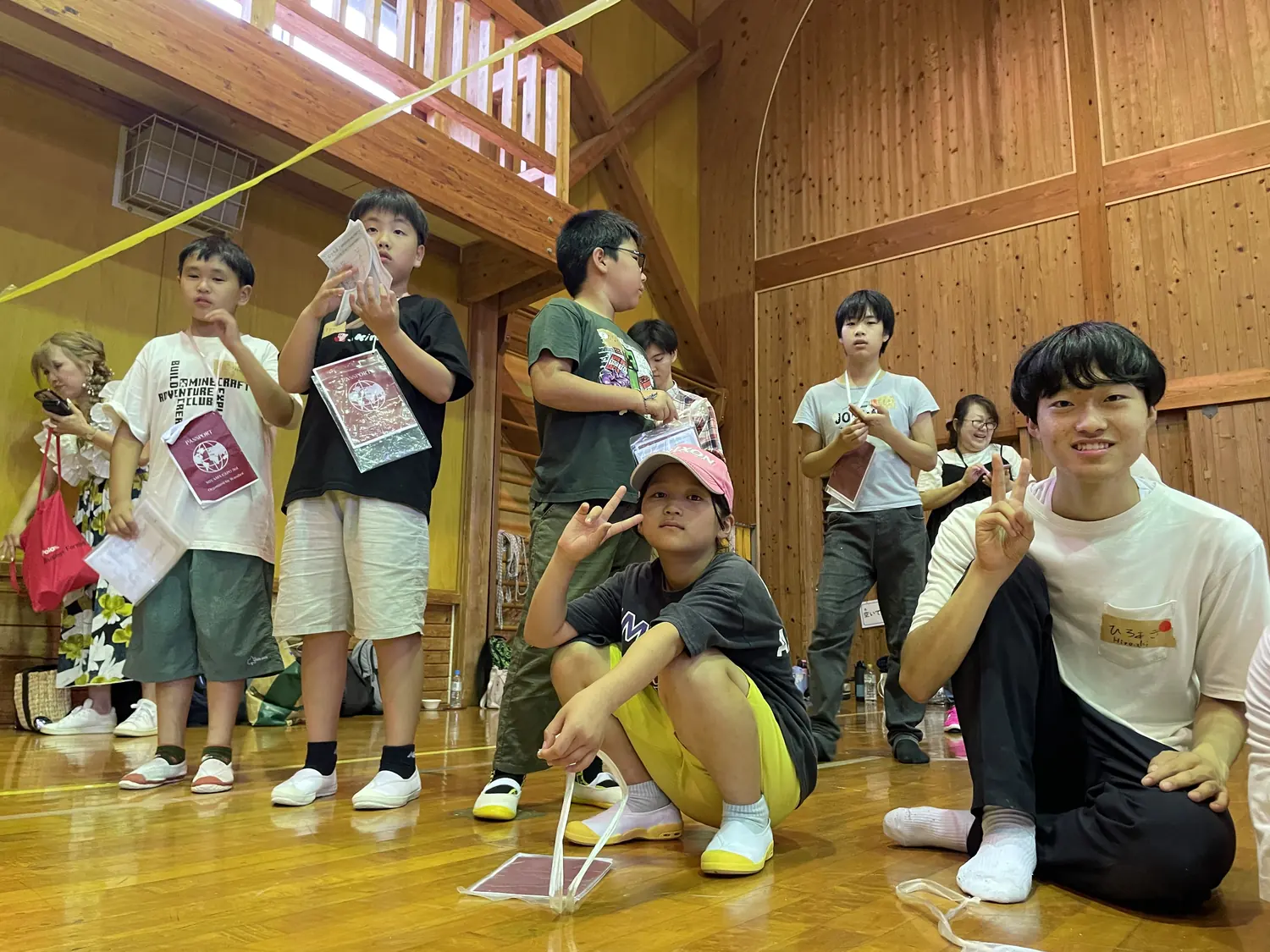 体験ブース — 通訳も兼ねた大学生スタッフと一緒にラボを回る子どもたち。
